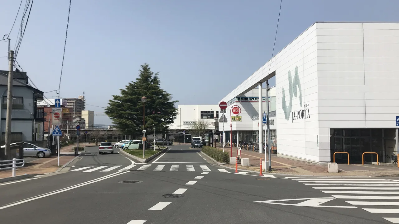 筑前前原駅南口へ続く通りと、JAポルタ（Aコープ前原駅南）の白い建物
